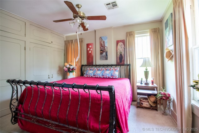 carpeted bedroom featuring ceiling fan and ornamental molding