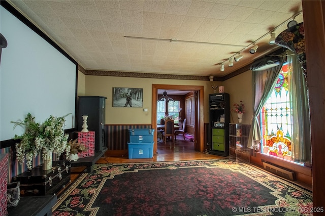 interior space featuring ornamental molding, wood finished floors, and wainscoting