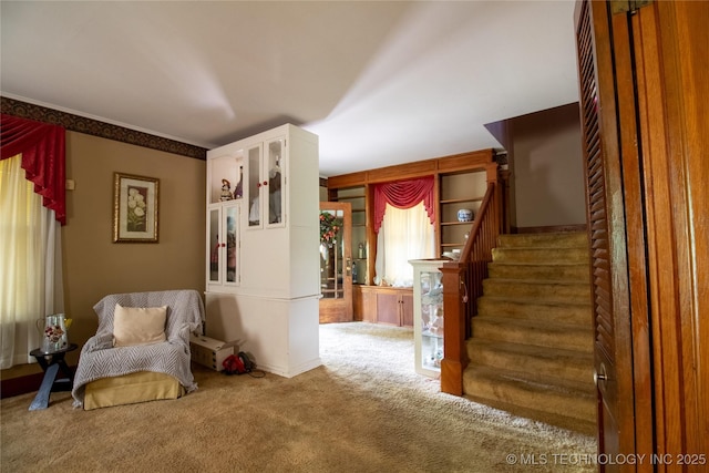 living area with carpet and stairs