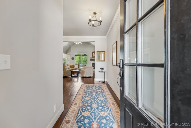 entrance foyer featuring crown molding, dark wood-style floors, a chandelier, baseboards, and ceiling fan