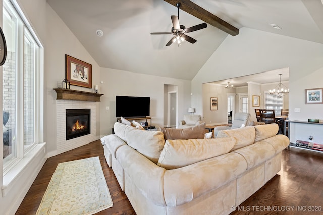 living area featuring a glass covered fireplace, beamed ceiling, healthy amount of natural light, high vaulted ceiling, and a chandelier