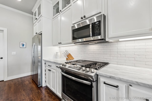 kitchen featuring stainless steel appliances, backsplash, crown molding, and light stone counters