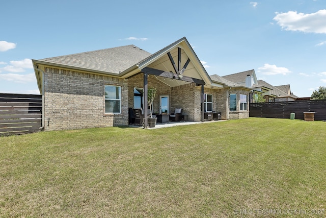 back of property with a patio area, brick siding, and roof with shingles