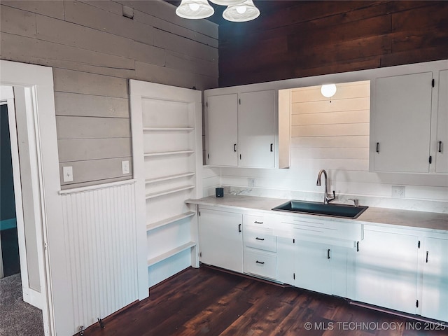 216 Belt Ave, Eufaula, OK 74432 - kitchen featuring a sink, wooden walls, light countertops, white cabinets, and dark wood-style flooring
