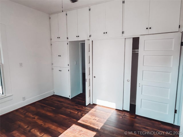 216 Belt Ave, Eufaula, OK 74432 - unfurnished bedroom with baseboards, dark wood finished floors, and a closet