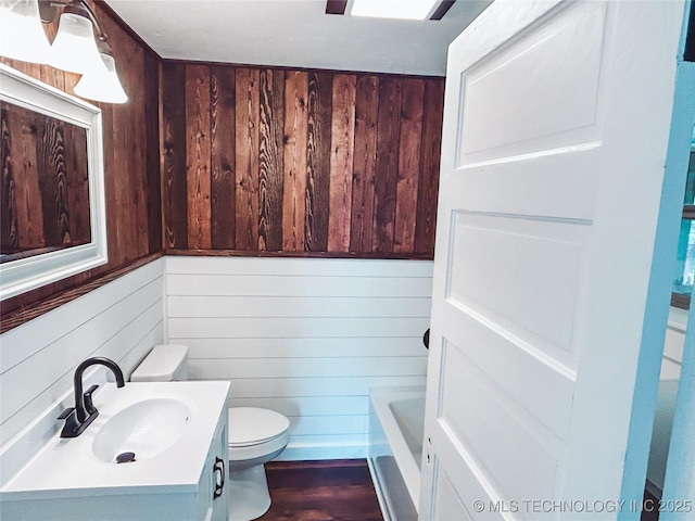 216 Belt Ave, Eufaula, OK 74432 - bathroom with wood walls, toilet, vanity, a tub, and wood finished floors