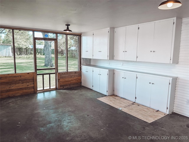 216 Belt Ave, Eufaula, OK 74432 - kitchen with concrete flooring, wooden walls, white cabinetry, and light countertops