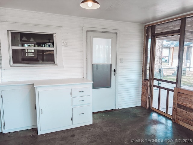 216 Belt Ave, Eufaula, OK 74432 - kitchen with concrete floors, light countertops, white cabinets, and wooden walls