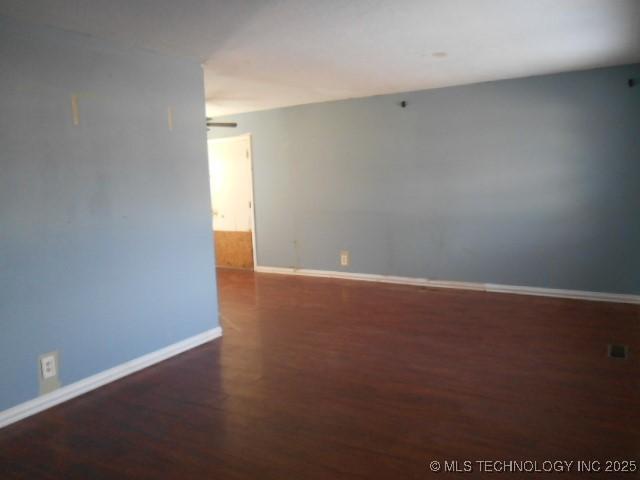 spare room with wood finished floors and baseboards