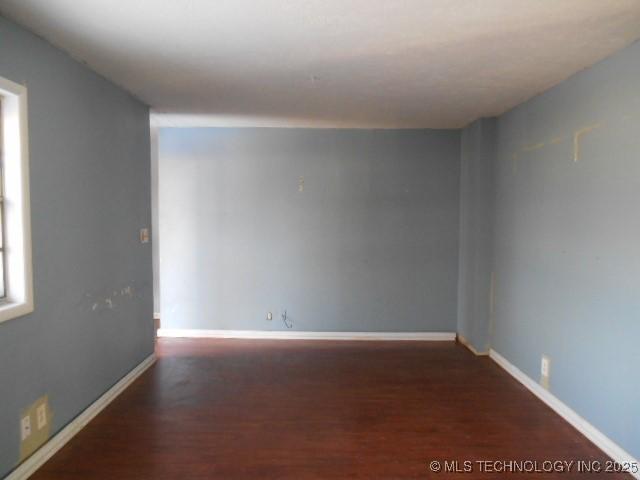 unfurnished room featuring wood finished floors and baseboards