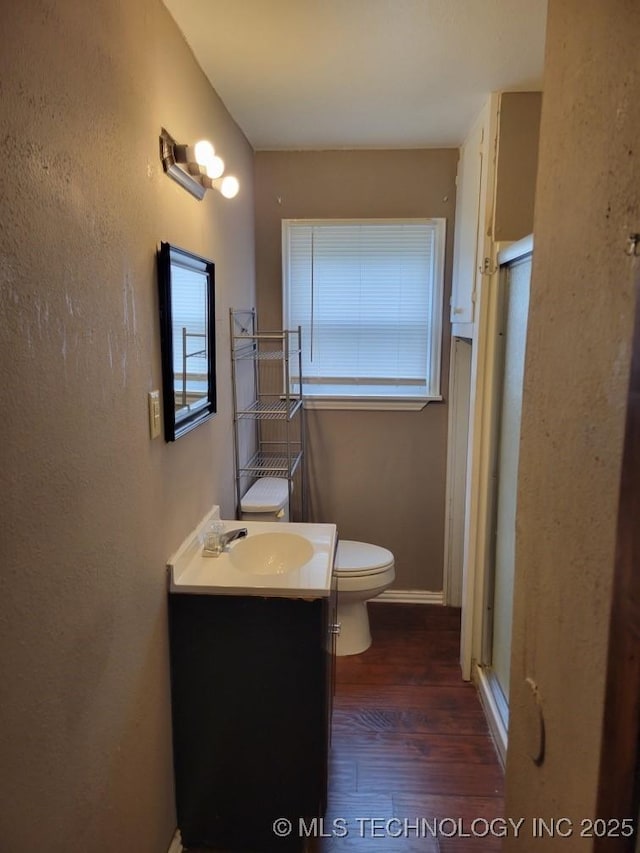 108 N Creek Ave, Bartlesville, OK 74003 - full bathroom with wood finished floors, a stall shower, vanity, toilet, and a textured wall