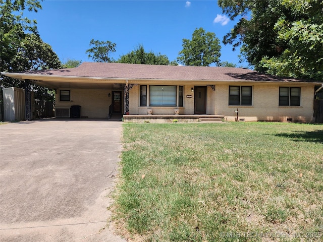 ranch-style house featuring brick siding, driveway, a carport, and a front yard