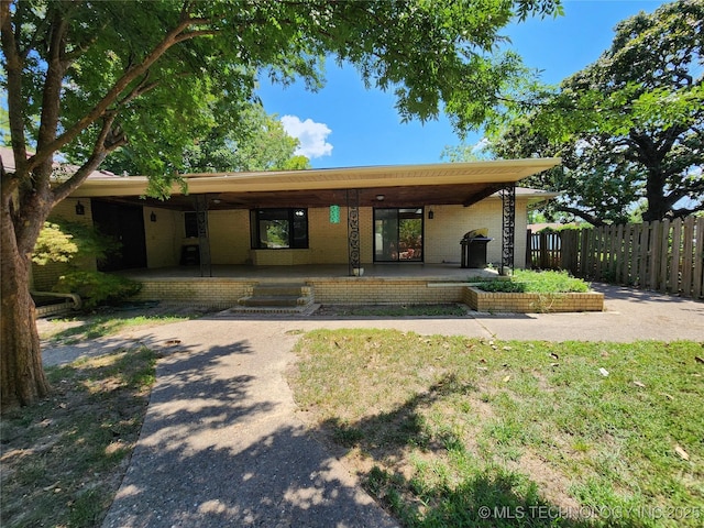 view of front of property featuring fence and brick siding