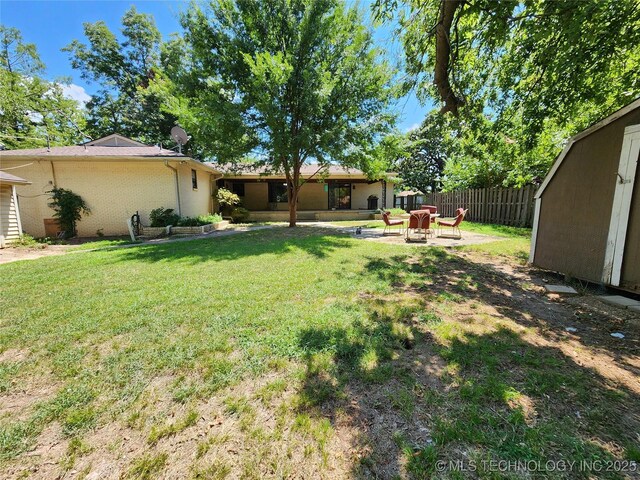 view of yard with a storage shed, an outbuilding, and an outdoor fire pit