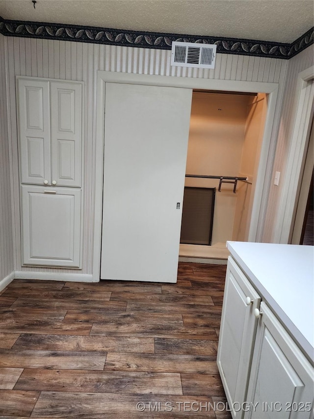 unfurnished dining area with dark wood-type flooring