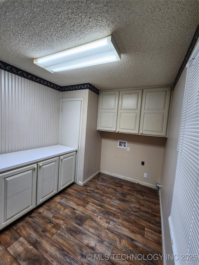 clothes washing area with cabinet space, hookup for a washing machine, dark wood-style flooring, a textured ceiling, and baseboards