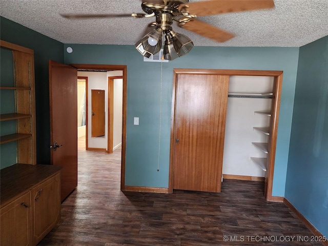 unfurnished bedroom with dark wood-style flooring, baseboards, a closet, a textured ceiling, and ceiling fan