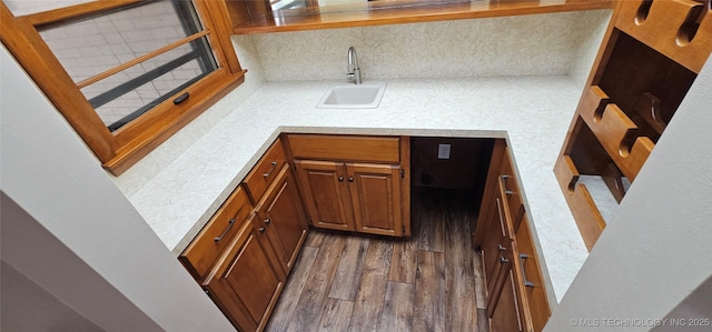 kitchen featuring a sink, tasteful backsplash, dark wood-style floors, light countertops, and brown cabinetry