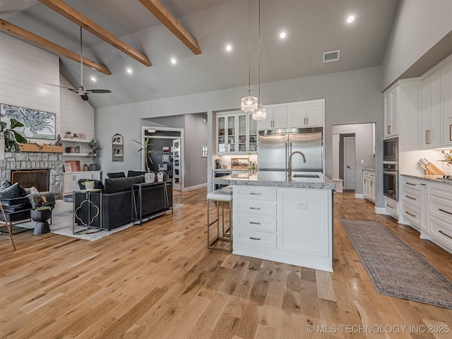 13606 S 21st Pl E, Bixby, OK 74008 - kitchen featuring built in appliances, high vaulted ceiling, open floor plan, white cabinets, and a sink