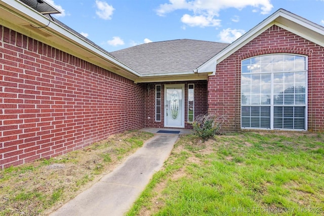 205 Summit, Durant, OK 74701 - view of exterior entry with brick siding and roof with shingles