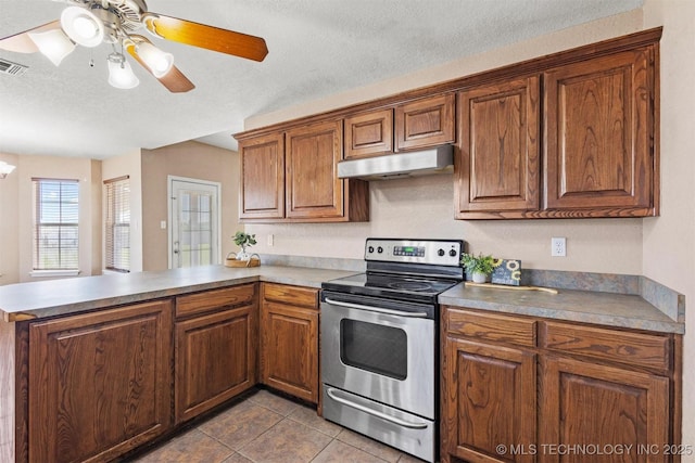 205 Summit, Durant, OK 74701 - kitchen featuring stainless steel range with electric cooktop, under cabinet range hood, a peninsula, tile patterned floors, and brown cabinets