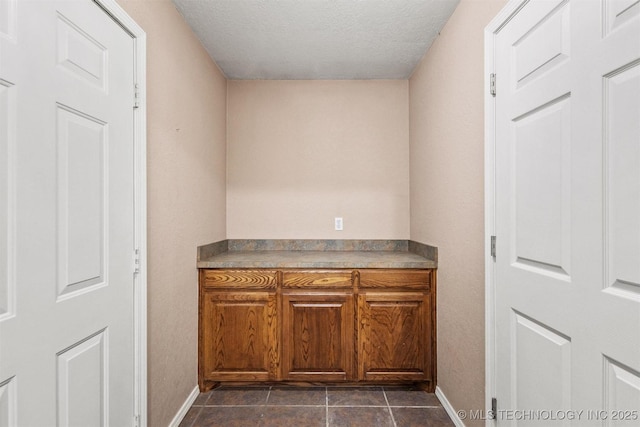 205 Summit, Durant, OK 74701 - bar area with baseboards, a textured ceiling, and dark tile patterned flooring