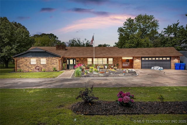 2961 N 24th St W, Muskogee, OK 74401 - ranch-style home with concrete driveway, a garage, a lawn, and brick siding