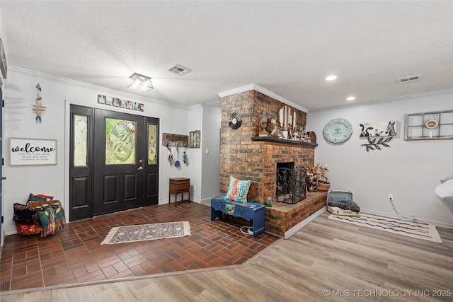 2961 N 24th St W, Muskogee, OK 74401 - entryway featuring a textured ceiling, a brick fireplace, ornamental molding, and recessed lighting