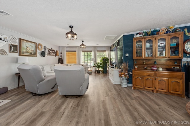 2961 N 24th St W, Muskogee, OK 74401 - living area with crown molding, light wood-style flooring, and a textured ceiling