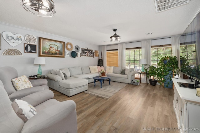 2961 N 24th St W, Muskogee, OK 74401 - living room featuring light wood-style flooring, a textured ceiling, and ornamental molding