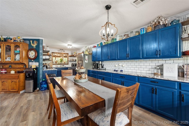 2961 N 24th St W, Muskogee, OK 74401 - dining room with a chandelier, light wood-type flooring, and a textured ceiling