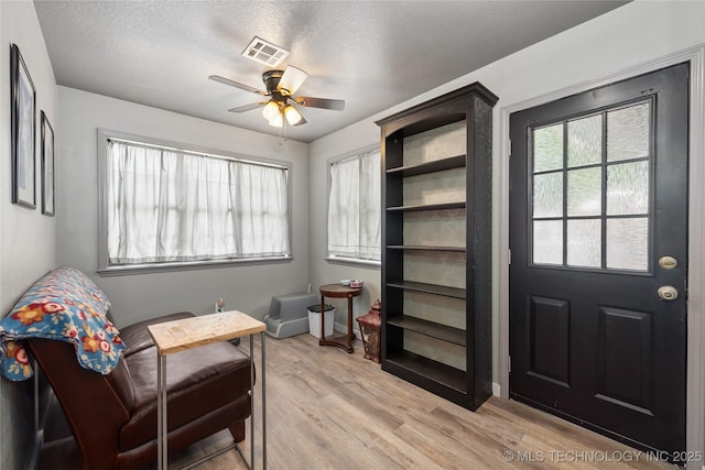 2961 N 24th St W, Muskogee, OK 74401 - living area featuring a ceiling fan, light wood-style floors, and a textured ceiling