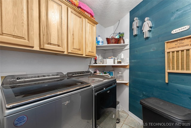 2961 N 24th St W, Muskogee, OK 74401 - laundry area featuring separate washer and dryer, cabinet space, a textured ceiling, light tile patterned flooring, and wooden walls