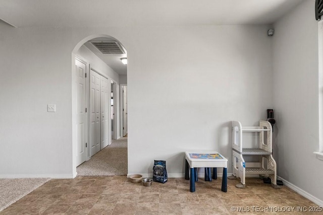 interior space featuring arched walkways and baseboards