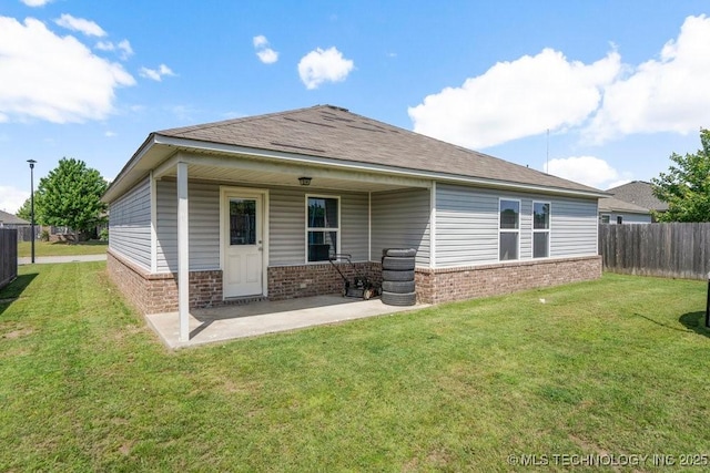 back of property with brick siding, a patio, and a shingled roof
