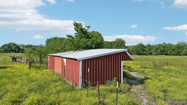 view of pole building with fence and a view of rural / pastoral area