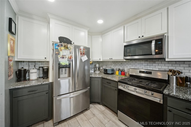 kitchen featuring appliances with stainless steel finishes, backsplash, white cabinetry, light stone countertops, and recessed lighting