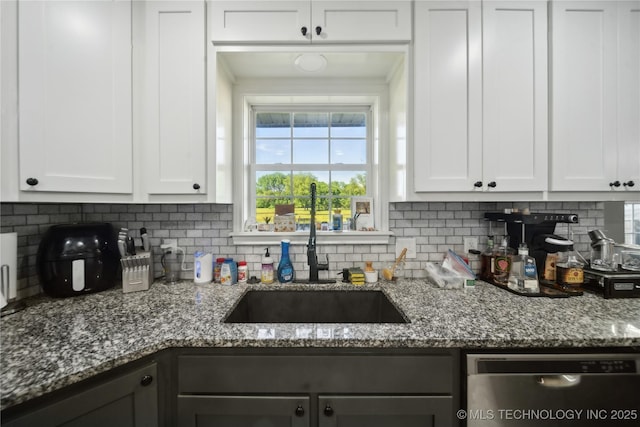 kitchen with dishwasher, backsplash, white cabinetry, and dark stone counters