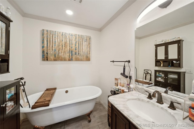 full bath featuring crown molding, a freestanding bath, vanity, and recessed lighting