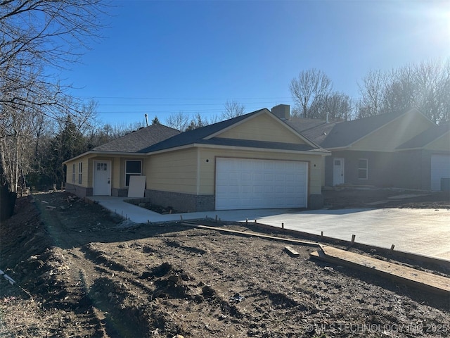 single story home featuring a garage, driveway, and brick siding