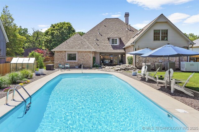 10105 S 72nd E Ave, Tulsa, OK 74133 - view of pool featuring a greenhouse, fence, a patio, an outdoor structure, and central air condition unit