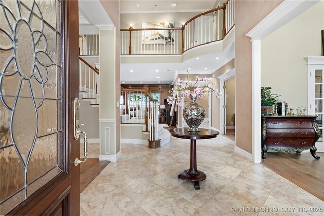 10105 S 72nd E Ave, Tulsa, OK 74133 - entryway with decorative columns, ornamental molding, stairway, a towering ceiling, and baseboards
