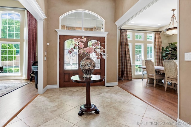 10105 S 72nd E Ave, Tulsa, OK 74133 - entryway featuring healthy amount of natural light, baseboards, a towering ceiling, light tile patterned floors, and ornamental molding