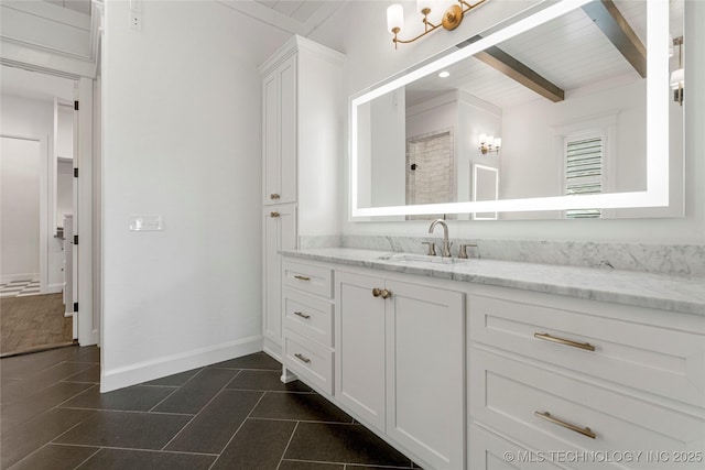bathroom featuring vanity, beam ceiling, baseboards, and tile patterned floors