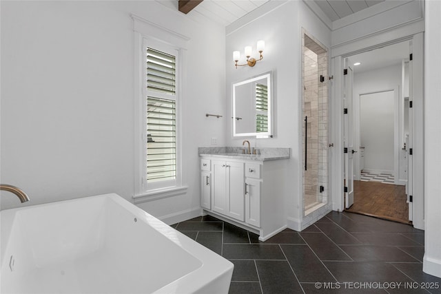 full bath with tile patterned floors, a soaking tub, a shower stall, vanity, and baseboards