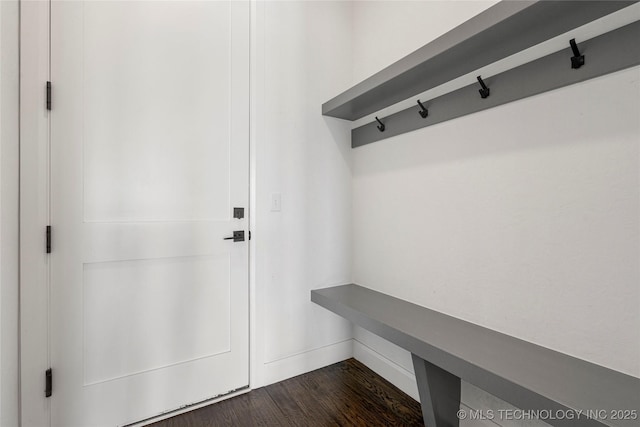 mudroom with dark wood-style flooring and baseboards