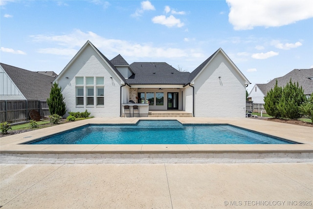 view of swimming pool with a patio, fence, and french doors