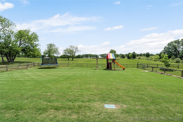 view of yard featuring a trampoline, a playground, and a view of countryside