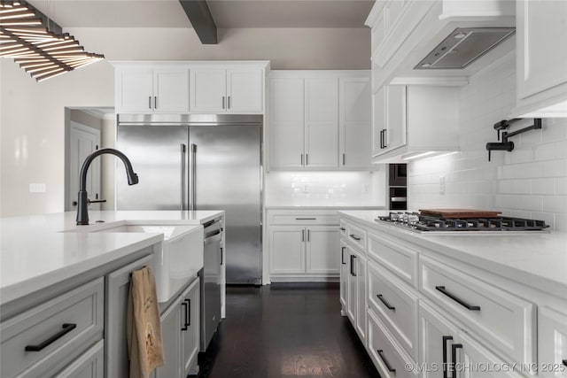 10616 N 81st E Pl, Owasso, OK 74055 - kitchen featuring appliances with stainless steel finishes, decorative backsplash, custom range hood, white cabinetry, and beam ceiling