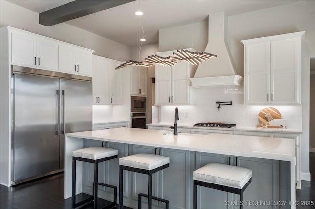 10616 N 81st E Pl, Owasso, OK 74055 - kitchen with built in appliances, custom range hood, white cabinets, backsplash, and light countertops